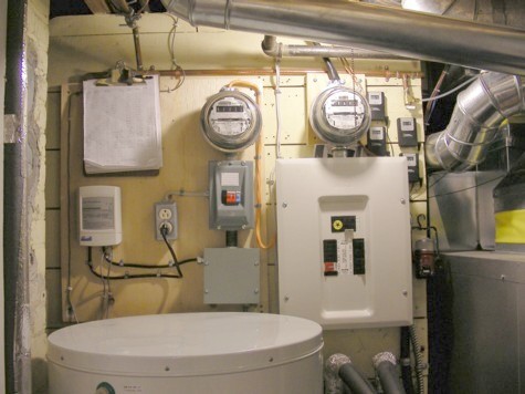 Basement load center - I track every kWh. Heat pump on right, solar hot water tank on left. System temp readouts at upper right - my tracking sheet upper left.